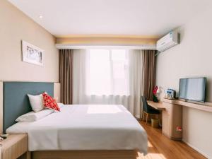 a hotel room with a bed and a window at Hanting Hotel Lvliang Citizen Square in Luliang