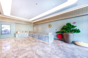 un grand hall avec une plante dans un grand vase dans l'établissement Ji Hotel Wenzhou Economic Development Zone Binhai Park, à Xingqianjie