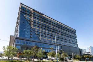 um edifício alto com muitas janelas em Ji Hotel Wenzhou Economic Development Zone Binhai Park em Xingqianjie