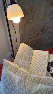 un libro abierto sentado en una cama con una lámpara en Sotto Le Stelle Home - una Baita in città, en Viterbo