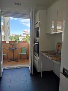 a kitchen with a balcony with a table and chairs at Cosy Vertigo apartment behind the hotel Martinez in Cannes