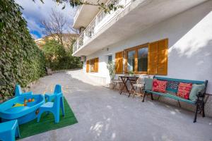 un patio con banco azul, mesa y sillas en Laurus apartments, en Rijeka