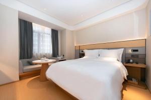 sypialnia z dużym białym łóżkiem i stołem w obiekcie Ji Hotel Xi'an Nanshaomen Provincial Stadium w mieście Xi'an