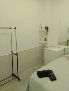 セビリアにあるLoft House Trianaのベッドルーム1室(ベッド1台、ブラックタオル付)