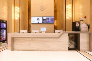 a lobby with a reception desk in a building at Hanting Hotel Jinan High-tech Zone Wanda Plaza in Hongjialou