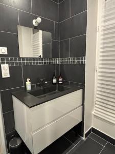 a bathroom with a sink and a mirror at Relax 1 bedroom apartment - EG01 in Enghien-les-Bains