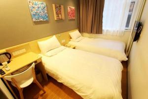 A bed or beds in a room at Hi Inn Qingdao Taishan Road Metro Station