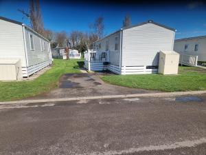 two mobile homes are parked next to a street at Sunnyside lodge in Cirencester