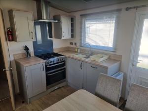 a small kitchen with a stove and a sink at Sunnyside lodge in Cirencester