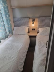 two beds sitting next to each other in a room at Sunnyside lodge in Cirencester