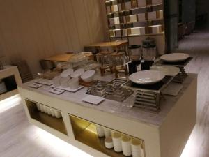 a table with white bowls and plates on it at Ji Hotel Yantai Penglai Zhonglou Dong Road in Penglai