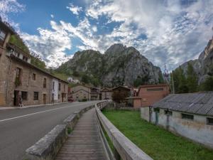 uma rua numa aldeia com montanhas ao fundo em Campo em La Hermida