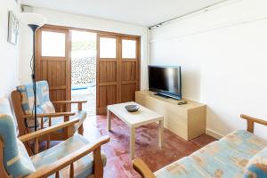 a living room with a couch and a tv at Villa Ponent in Son Bou