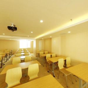 une salle de classe avec des tables et des chaises dans une salle dans l'établissement Ji Hotel Harbin Zhongyang Da Street Suofeiya, à Harbin