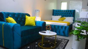a living room with a blue couch and a bed at DefiniteHomes1 - Fully furnished studio with a rooftop restaurant near JKIA Airport, Downtown Nairobi in Nairobi