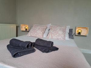 Una cama con toallas y dos luces. en La petite bajocasse en Bayeux