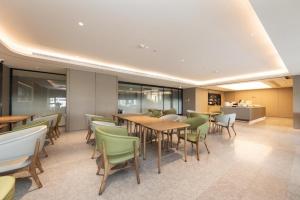 un restaurante con mesas de madera y sillas verdes en Ji Hotel Changde Tianrun Plaza, en Changde