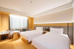 Habitación de hotel con 2 camas y mesa en Ji Hotel Changzhi Xi Bus Station, en Changzhi