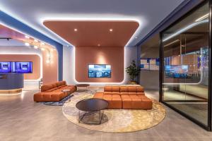 - une salle d'attente avec des canapés et des chaises dans un bâtiment dans l'établissement Hanting Hotel Suzhou Guanqian Street Center, à Suzhou