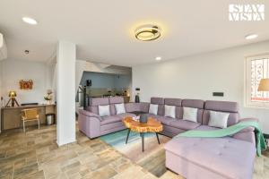 a living room with purple couches and a table at StayVista at The Ganga House - Holy River Varanasi in Varanasi