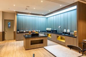 a kitchen with blue walls and a table and chairs at Hanting Hotel Wuhan Jiedaokou Metro Station in Han-yang-hsien