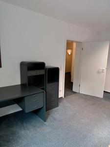 an empty room with a desk and a closet at City-Residenz Ge-Buer in Gelsenkirchen