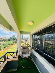 un balcón con una silla de mimbre y una ventana en Azania Homes 2bedrooms Apartments Westlands, en Nairobi