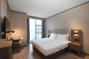 Postel nebo postele na pokoji v ubytování Hanting Hotel Jurong Wuyue Plaza