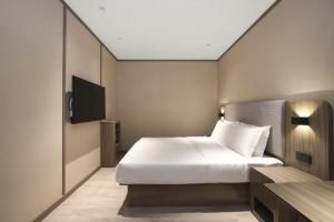 Postel nebo postele na pokoji v ubytování Hanting Hotel Jurong Wuyue Plaza