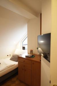 a bedroom with a bed and a flat screen tv at Arena Apartments in Graz
