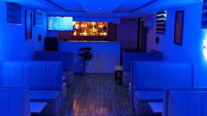 um quarto azul com cadeiras azuis e um bar em Kosam Global Hotel and Suites em Uyo