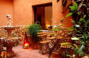 a patio with a table and chairs and plants at Hotel Baviera in Linares