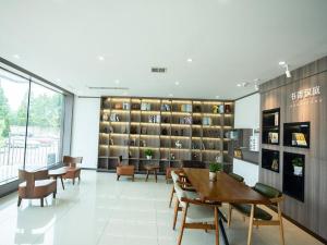 a large room with a library with tables and chairs at Hanting Hotel Jiaozhou Jiaodong International Airport in Madian