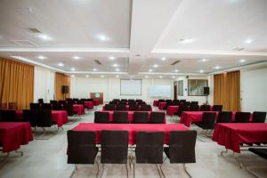a conference room with red tables and chairs and a screen at Hanting Hotel Jiaozhou Jiaodong International Airport in Madian