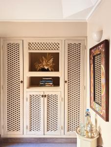 a white cabinet with wooden louvered doors in a room at Riad Abracadabra in Marrakech