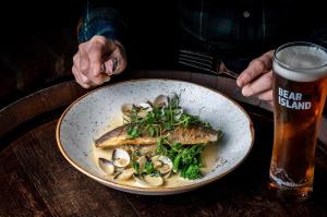 a plate of fish with mushrooms and a glass of beer at The Bull on the Green in Newick