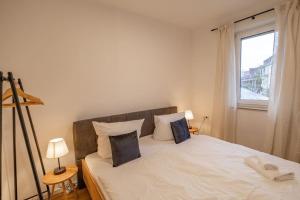 a bedroom with a large white bed with a window at Messe Innenstadt Zentrum Apartment in Bremen