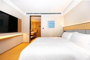 南京的住宿－Ji Hotel Nanjing Confucius Temple Sanshan Street，卧室配有一张白色大床和一台平面电视。