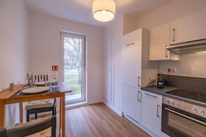a kitchen with white cabinets and a sink and a window at Messe Innenstadt Zentrum Apartment in Bremen