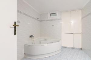 La salle de bains blanche est pourvue d'une baignoire. dans l'établissement Comfy apartment for 6 people in Heraklion, à Héraklion
