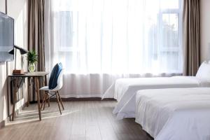 Un pat sau paturi într-o cameră la Hanting Hotel Yuncheng Xinjiangjiangzhou Avenue