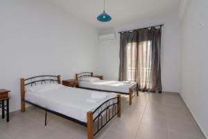 Cette chambre comprend 3 lits et une fenêtre. dans l'établissement Comfy apartment for 6 people in Heraklion, à Héraklion