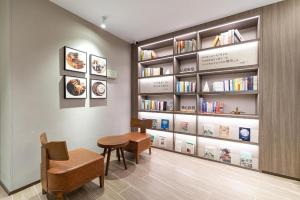 una habitación con una mesa y una estantería con libros en Hanting Hotel Nanjing Fuzimiao Scenic Spot en Kao-ch'iao