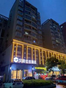 un grand bâtiment avec des lumières devant lui dans l'établissement Hanting Premium Hotel Youjia Wuhan Etouwan Metro Station, à Wujiashan