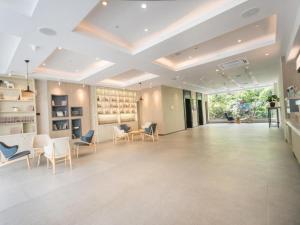 duży pokój z krzesłami i stołami oraz sufitem w obiekcie Hanting Premium Hotel Youjia Suzhou Guanqian Street w mieście Suzhou