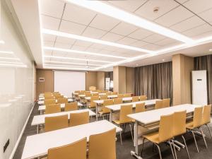 a classroom with tables and chairs in a room at Hanting Premium Hotel Youjia Suzhou Guanqian Street in Suzhou