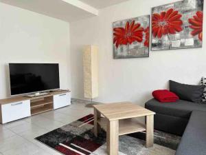 sala de estar con sofá y TV en Wohnung in idyllischer Lage en Ammerbuch
