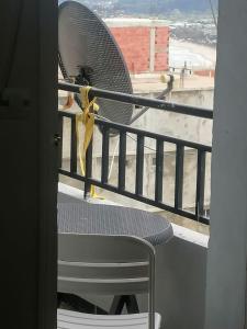 una sedia con un fiocco giallo seduta su un balcone di tres belle vue sur la mer a Collo