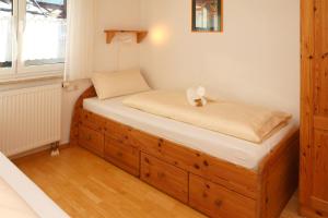 um pequeno quarto com uma cama e um armário de madeira em Allgäu Oase - fewo-badhindelang em Bad Hindelang