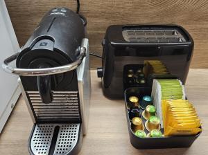 a toaster sitting on a table next to a container of buttons at CosyNook - refait à neuf proche parc des expositions et aéroport CDG - Parking privé gratuit in Villepinte